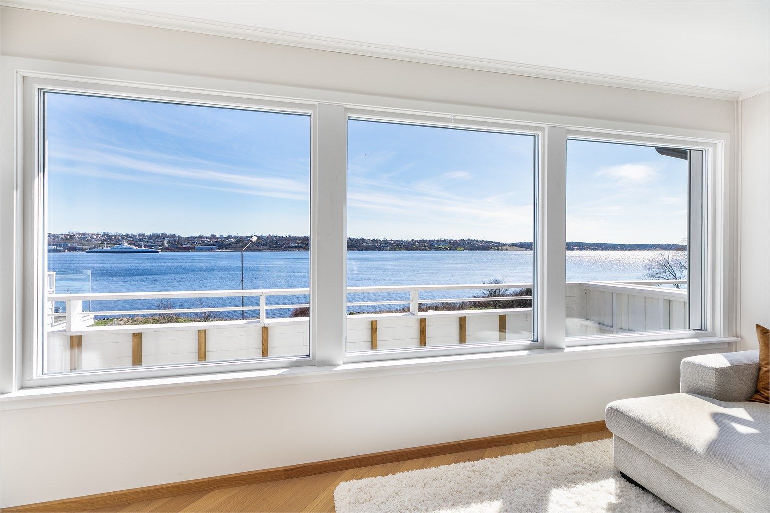 Rekken av store vinduer ivaretar den flotte sjøutsikten og gir stuen gode lysforhold dagen gjennom. Alle ble byttet ut i 2022.