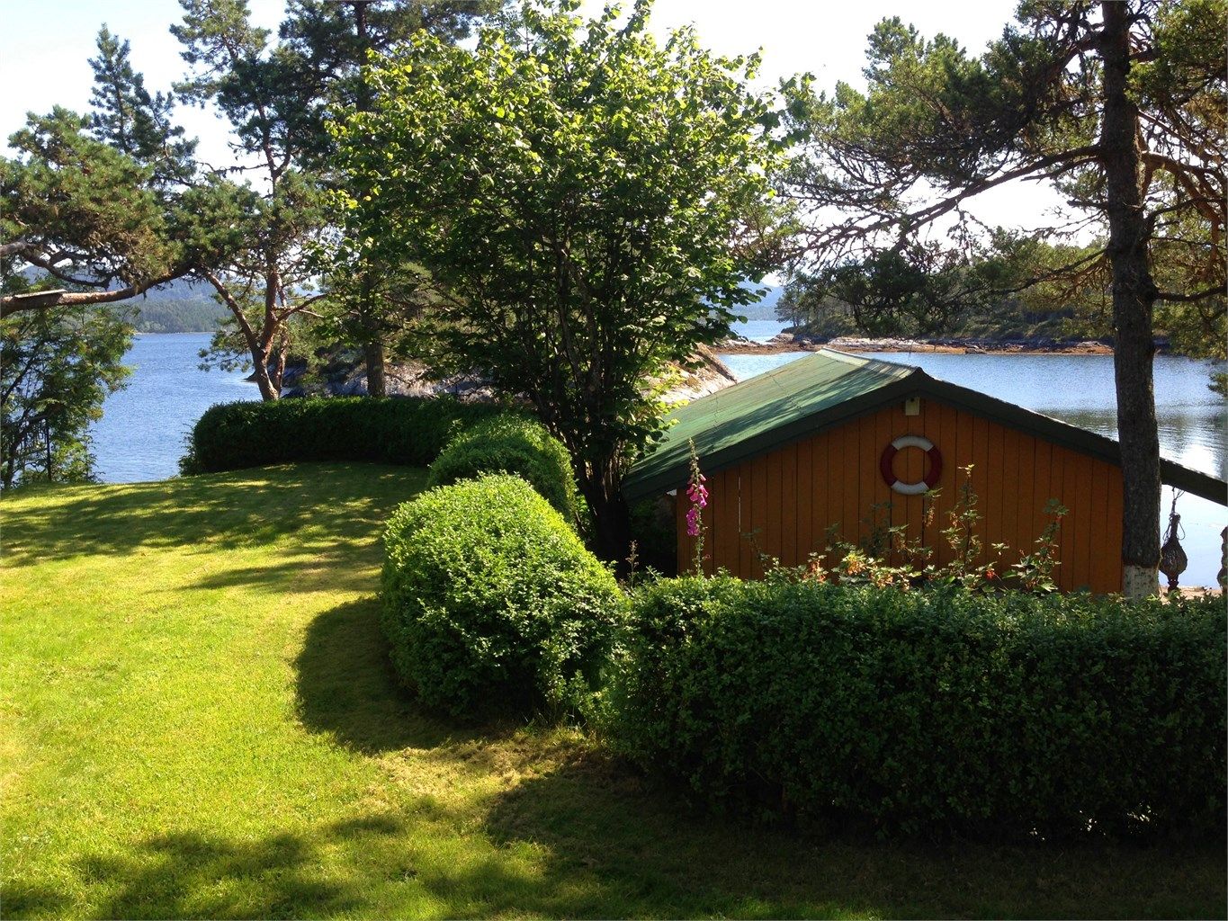 Tomten er pent opparbeidet med plen og beplantning, samt fine muligheter for bading og lek