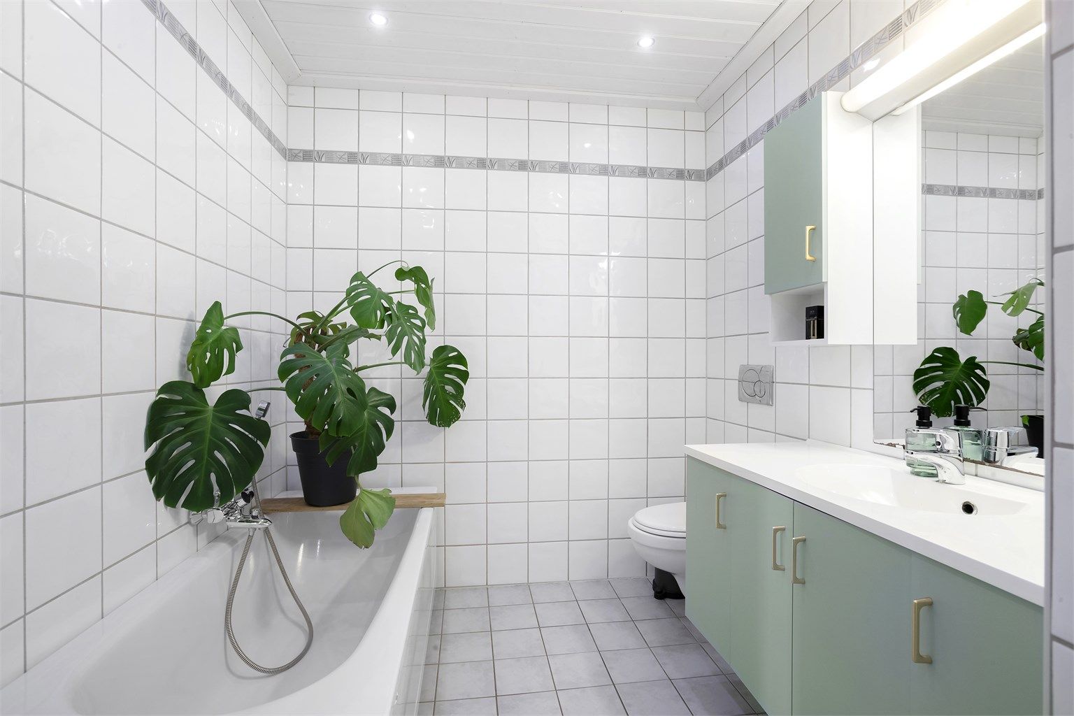 Badet er praktisk innredet med både dusjhjørne og badekar.