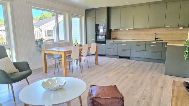 Stue og kjøkken i åpen løsning skaper et lyst og sosialt allrom.