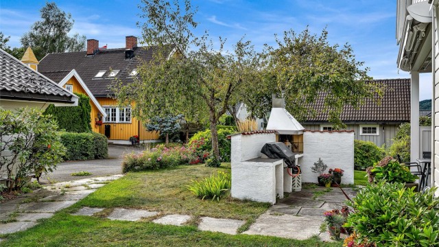 Hagen er pent opparbeidet med plen, beplantning og frukttrær (epler og plommer, samt ripsbusker)