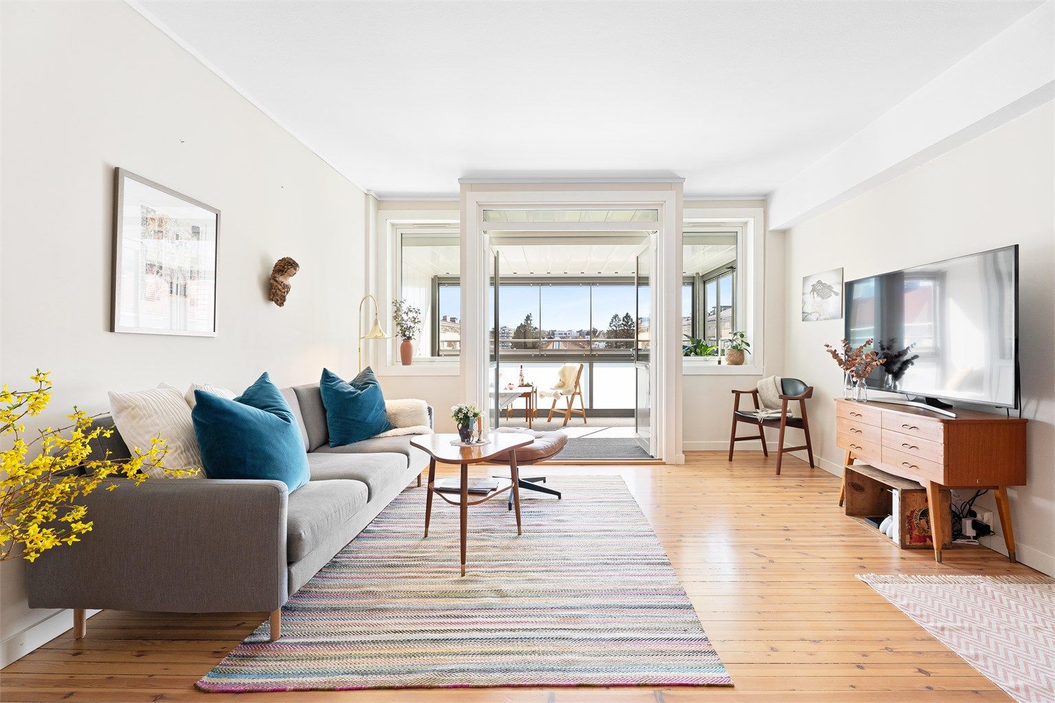 Romslig stue med dobbel glassdør ut til solrik balkong