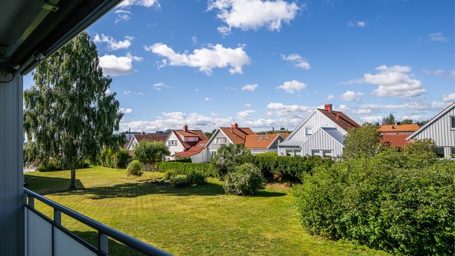 Fra balkongen ser man ut over borettslagets store, grønne fellesarealer.