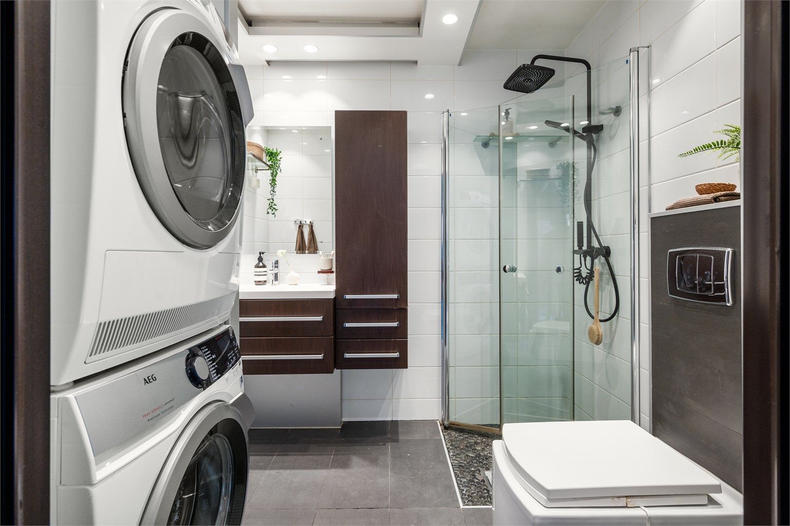 Tidløst og romslig baderom bestående av flislagte vegger og malte flater i himling.