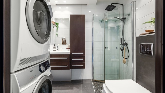 Tidløst og romslig baderom bestående av flislagte vegger og malte flater i himling.