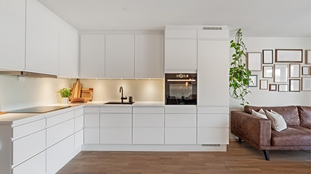 Kjøkkeninnredning fra Aubo med hvite, slette fronter og laminatbenkeplate.