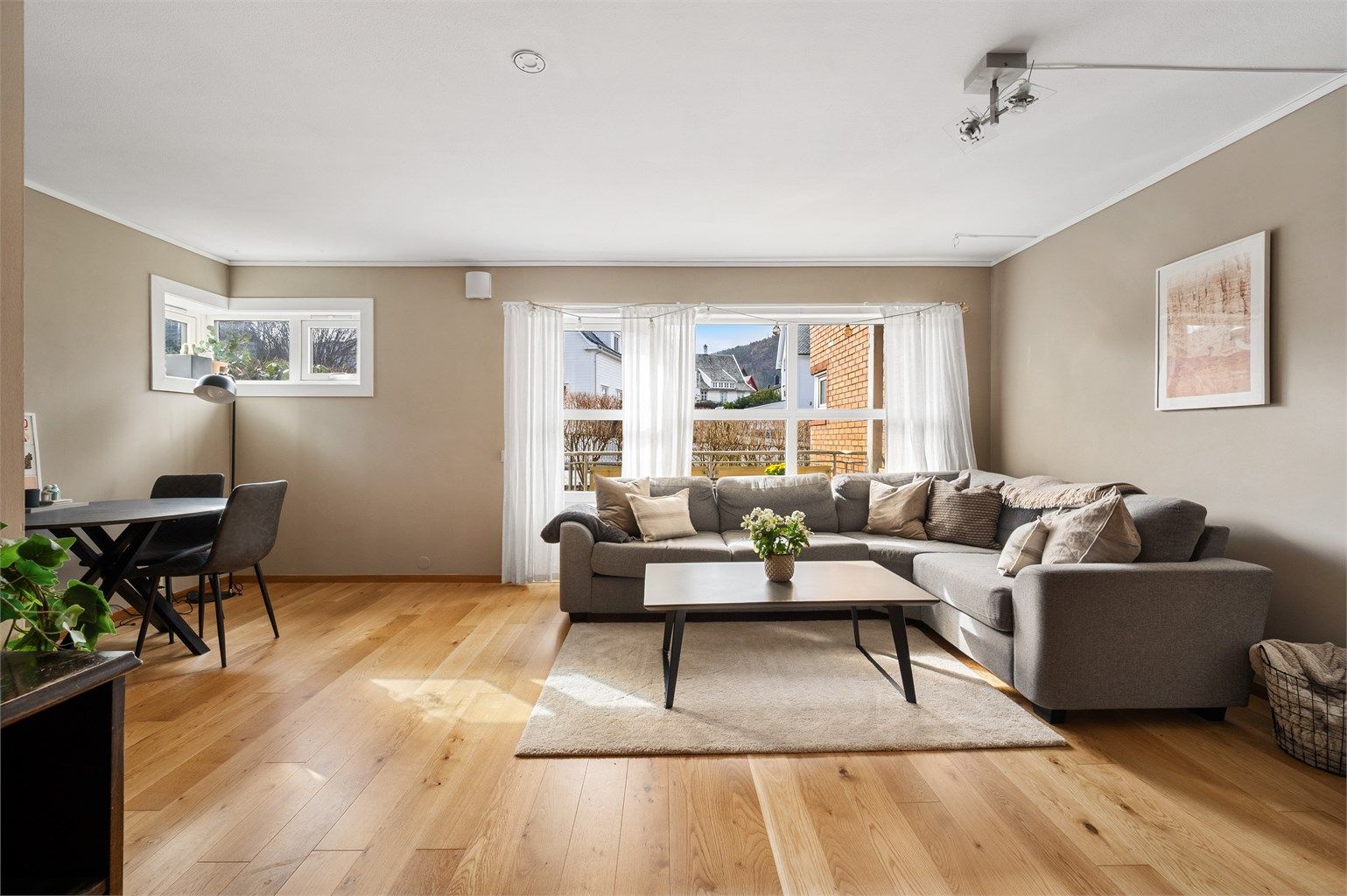 Lys og luftig stue med parkett på gulv og slette vegger i behagelige fargetoner