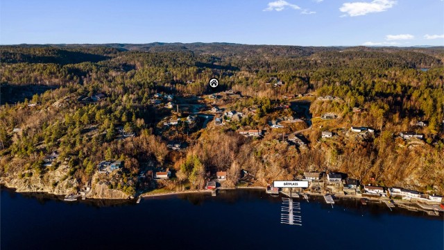 Gangavstand til sjøen med badestrand og båtplass i felles bryggeanlegg.