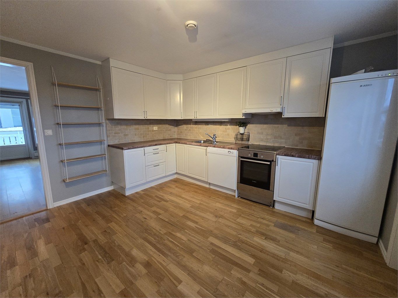 Lys kjøkkeninnredning med laminert benkeplate. 