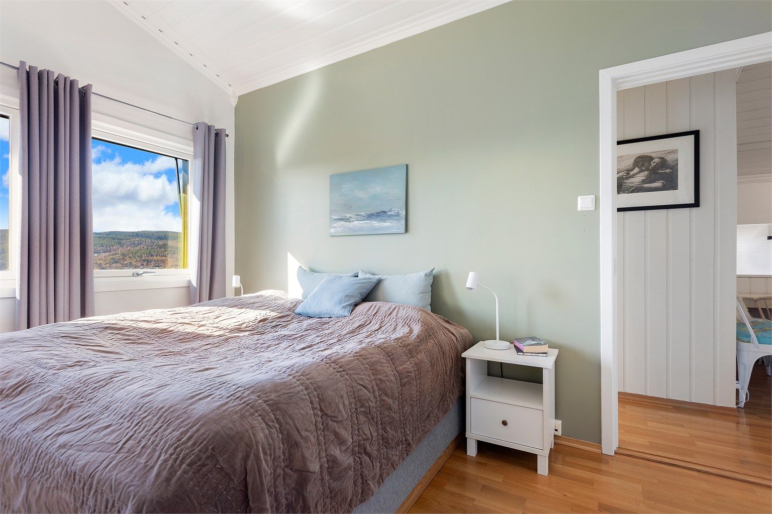 Rommet har parkett på gulvet og malt panel i taket, som i resten av etasjen.