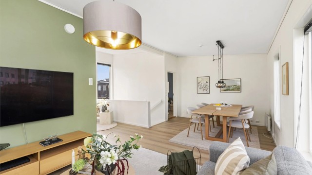 Tv-stuen har lun atmosfære med tidsriktige fargevalg og god plass til sofagruppe.