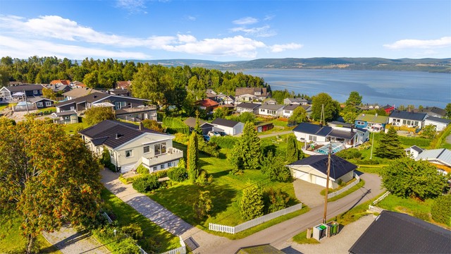 Rolige omgivelser preget av eneboligbebyggelse og store, grønne hager.
