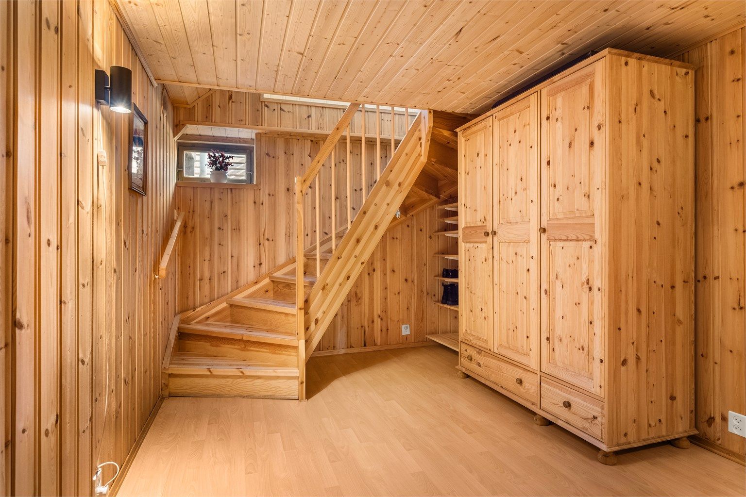 Trapperommet ned til kjelleren. Hele etasjen har panel på vegger og i tak.