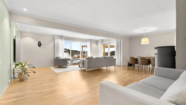Videre kommer du inn til boligens stue. Lys og lett med plass til flere sittegrupper
