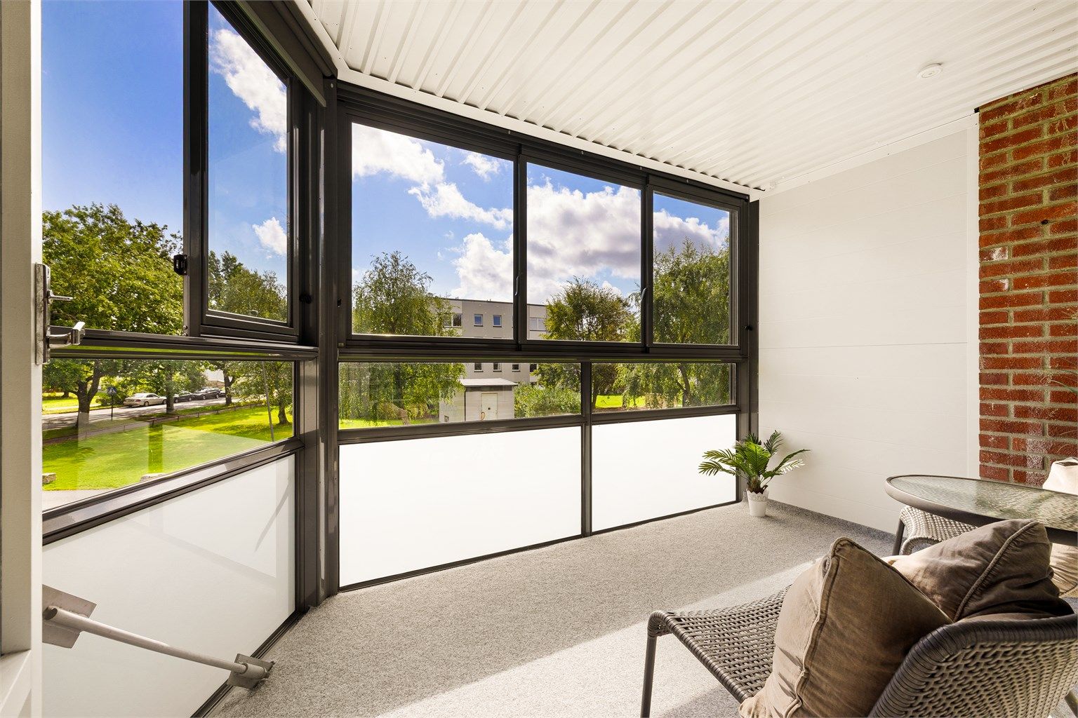 Skjermende glass utvider bruksmulighetene og gjør den nylig renoverte verandaen nærmest til et ekstra rom.