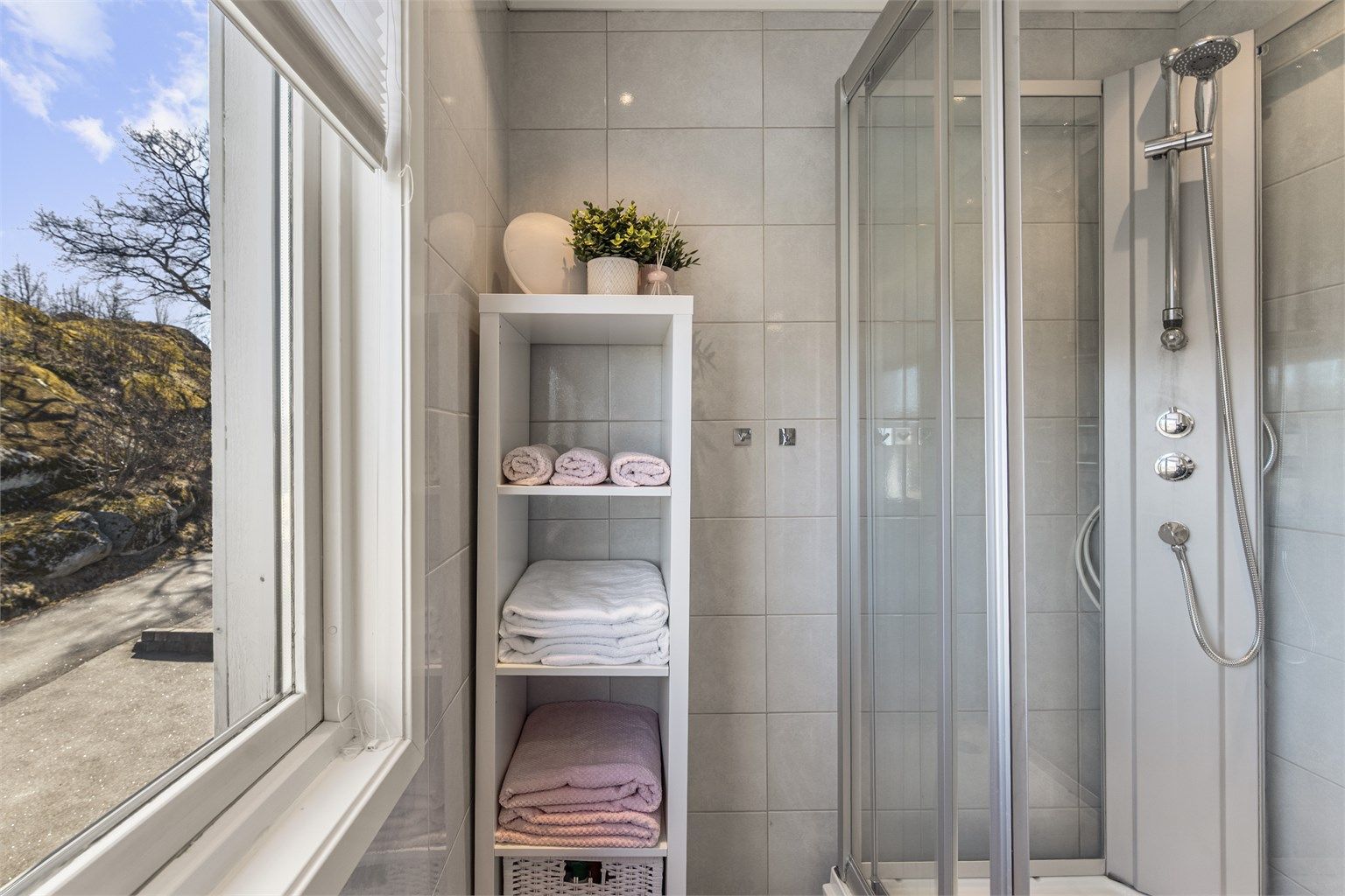 Badet er utstyrt med dusjkabinett og har elektrisk avtrekksvifte.