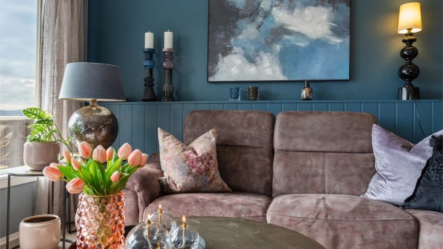 Gjennomgående materialvalg som laminat på gulv og panelbord i himling skaper et helhetlig uttrykk i boligen.