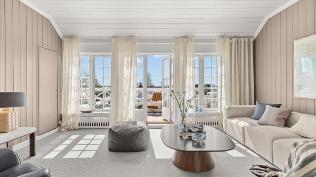 Lys og romslig tv-stue med store sprossede vinduer mot syd