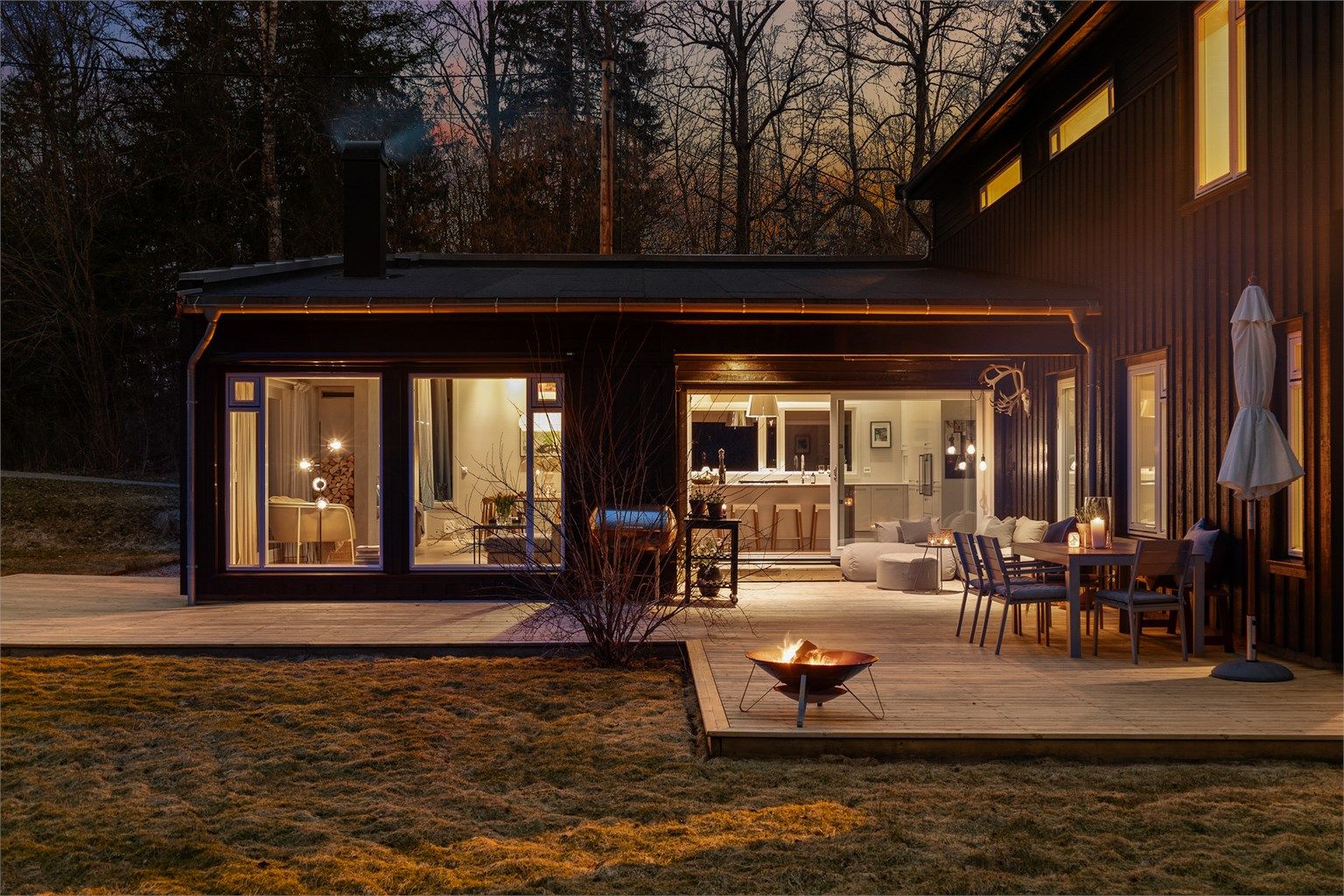 Koselig sitteplass under tak med utgang fra kjøkkenet og fra entreen/gangen.