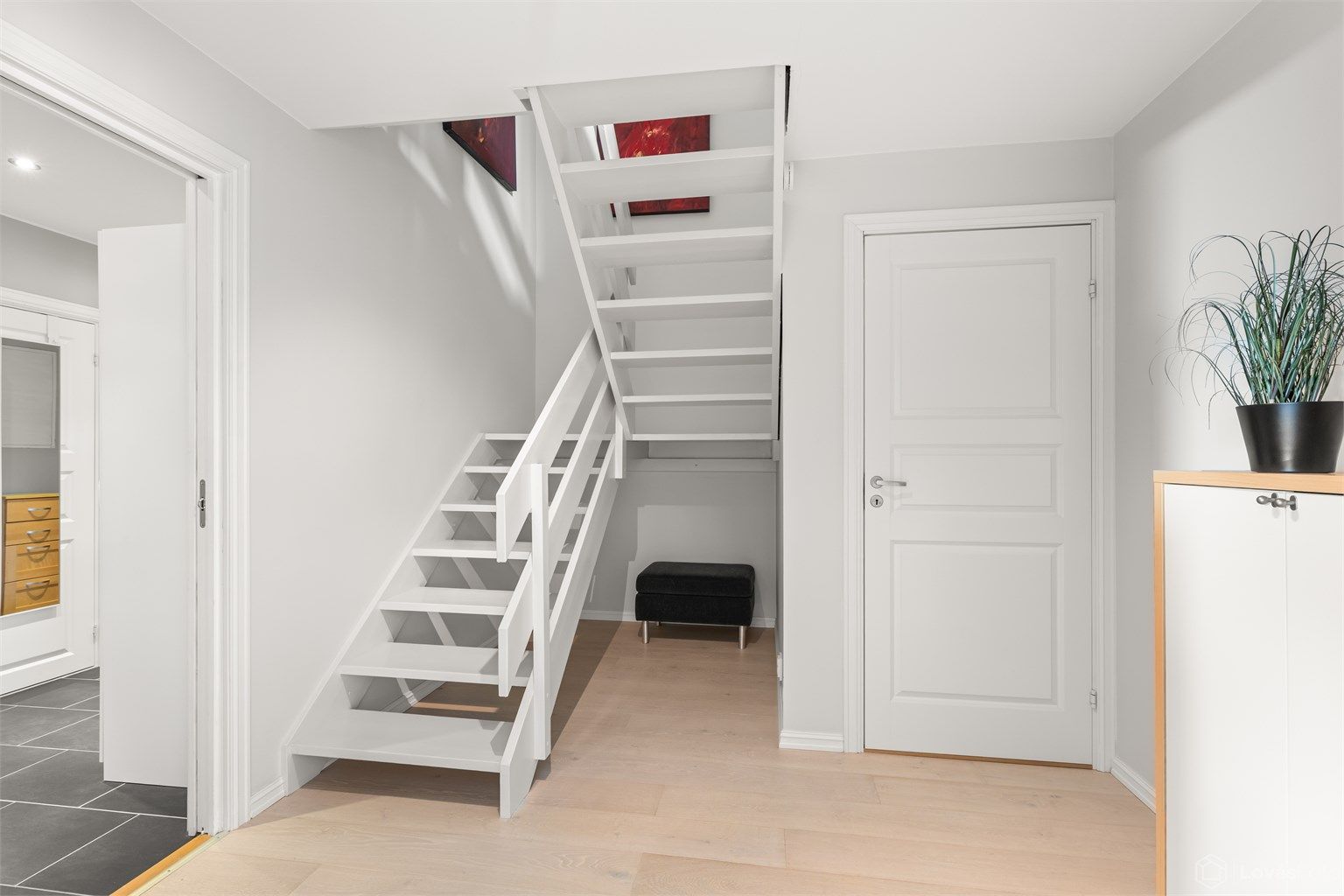 Romslig hall med plass til oppbevaring, og som binder de to etasjene sammen.