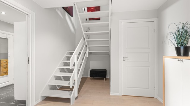 Romslig hall med plass til oppbevaring, og som binder de to etasjene sammen.