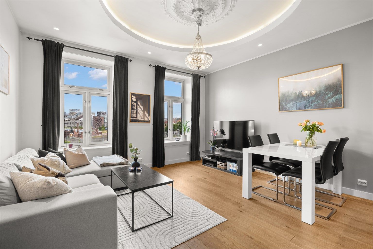 Lys og luftig stue/spisestue med åpen kjøkkenløsning – et sosialt og innbydende oppholdsrom med god plass til både sofagruppe og spisebord med tilhørende møblement. 