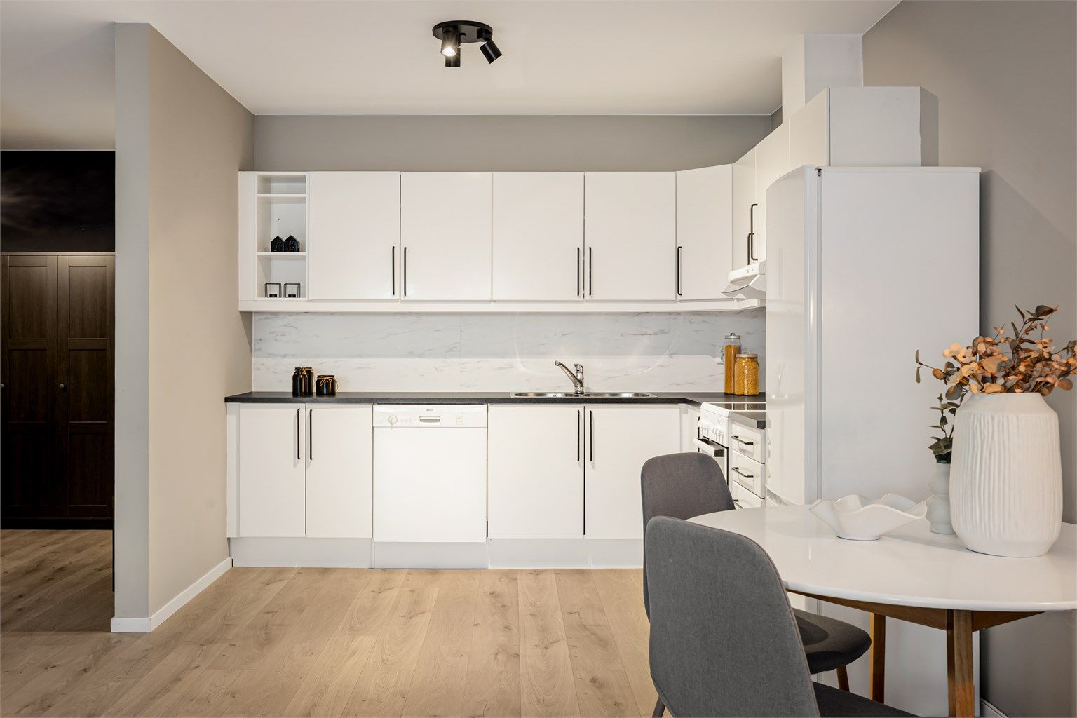 Sigdal-kjøkkeninnredning med over- og underskap i hvit samt glatt utførelse