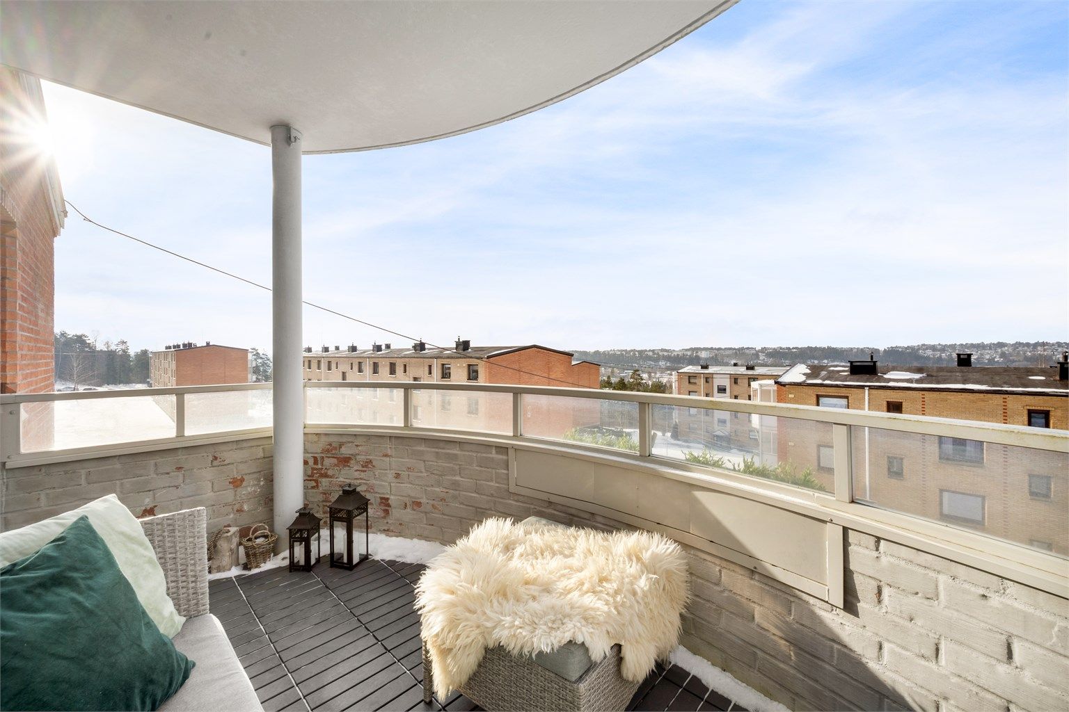 Balkongen har gulv belagt med plastfliser og en åpen utsikt over nærområdet.