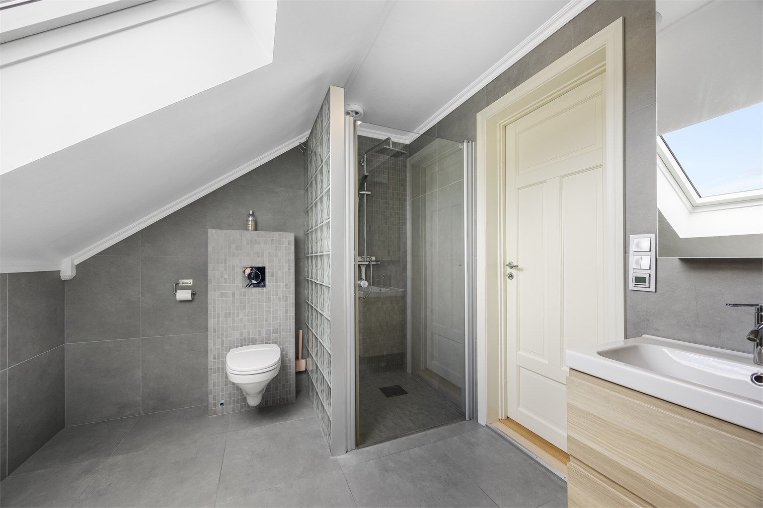 I tillegg til badekar har badet en egen dusjnisje med regndusj og vegghengt toalett.