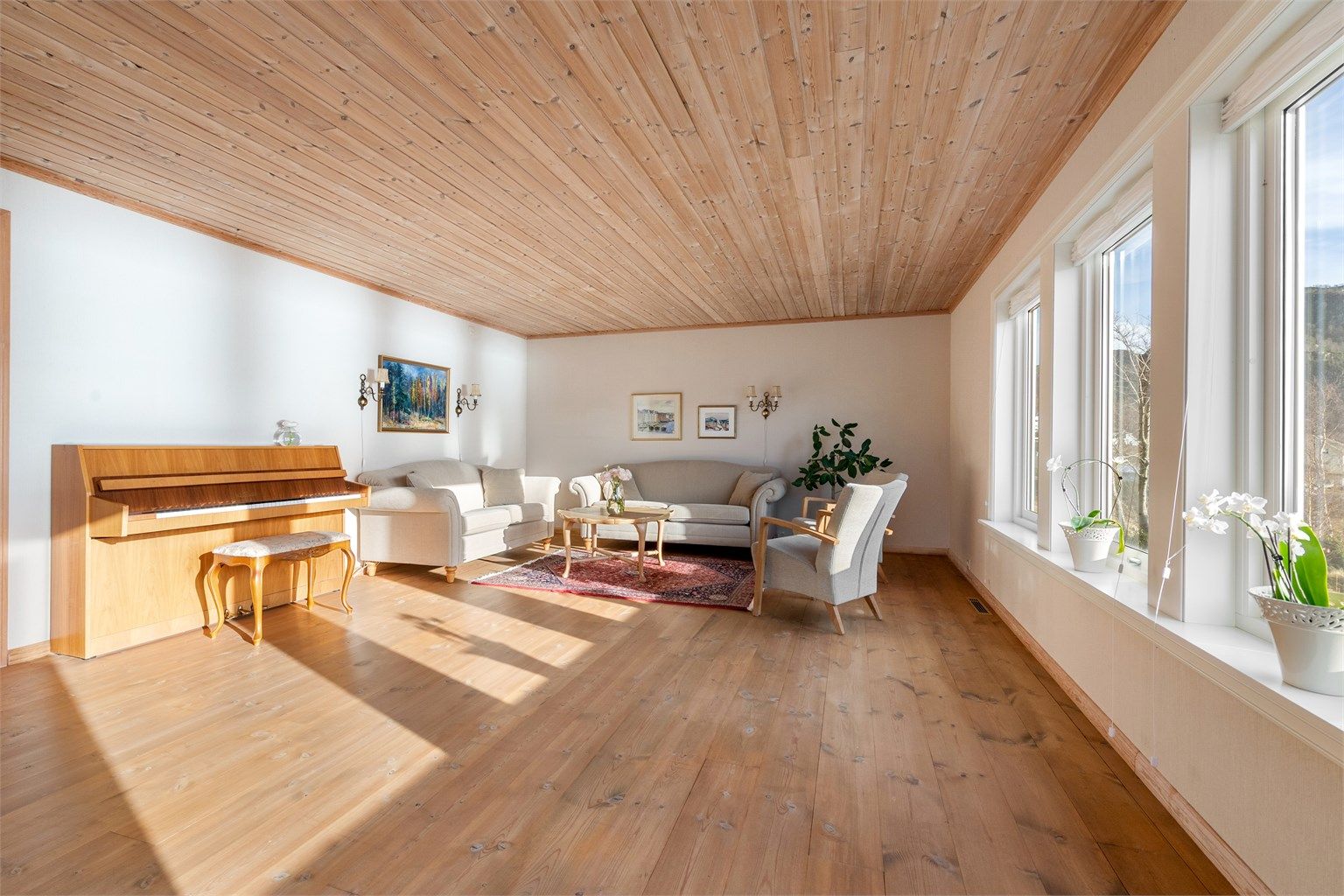 Lys stue med flott utsikt mot fjord og fjell