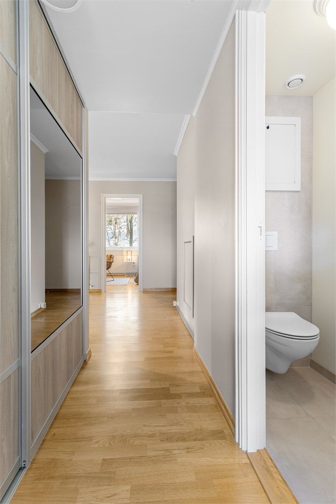 Gang mellom entre og kjøkken med skyvedørsgarderobe og adkomst til toalettrom