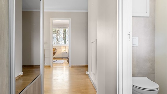 Gang mellom entre og kjøkken med skyvedørsgarderobe og adkomst til toalettrom