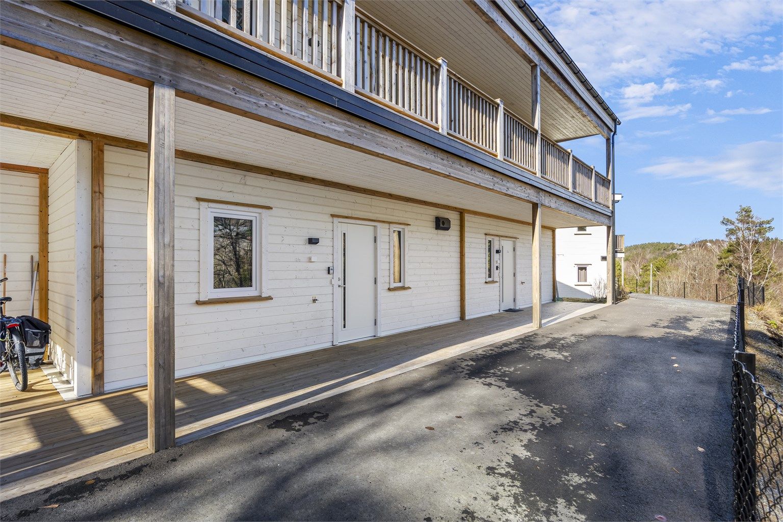 Baksiden/ved inngangspartiet er det også takoverbygg, asfaltert - og faktisk mulig å kjøre til døra. Området nedenfor er friområde og nedenfor de to andre byggene er det planlagt 20 leiligheter.