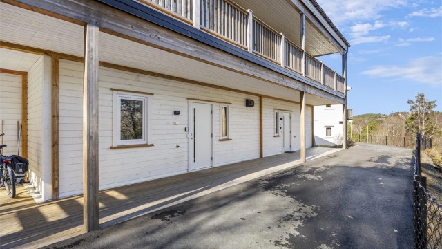 Baksiden/ved inngangspartiet er det også takoverbygg, asfaltert - og faktisk mulig å kjøre til døra. Området nedenfor er friområde og nedenfor de to andre byggene er det planlagt 20 leiligheter.