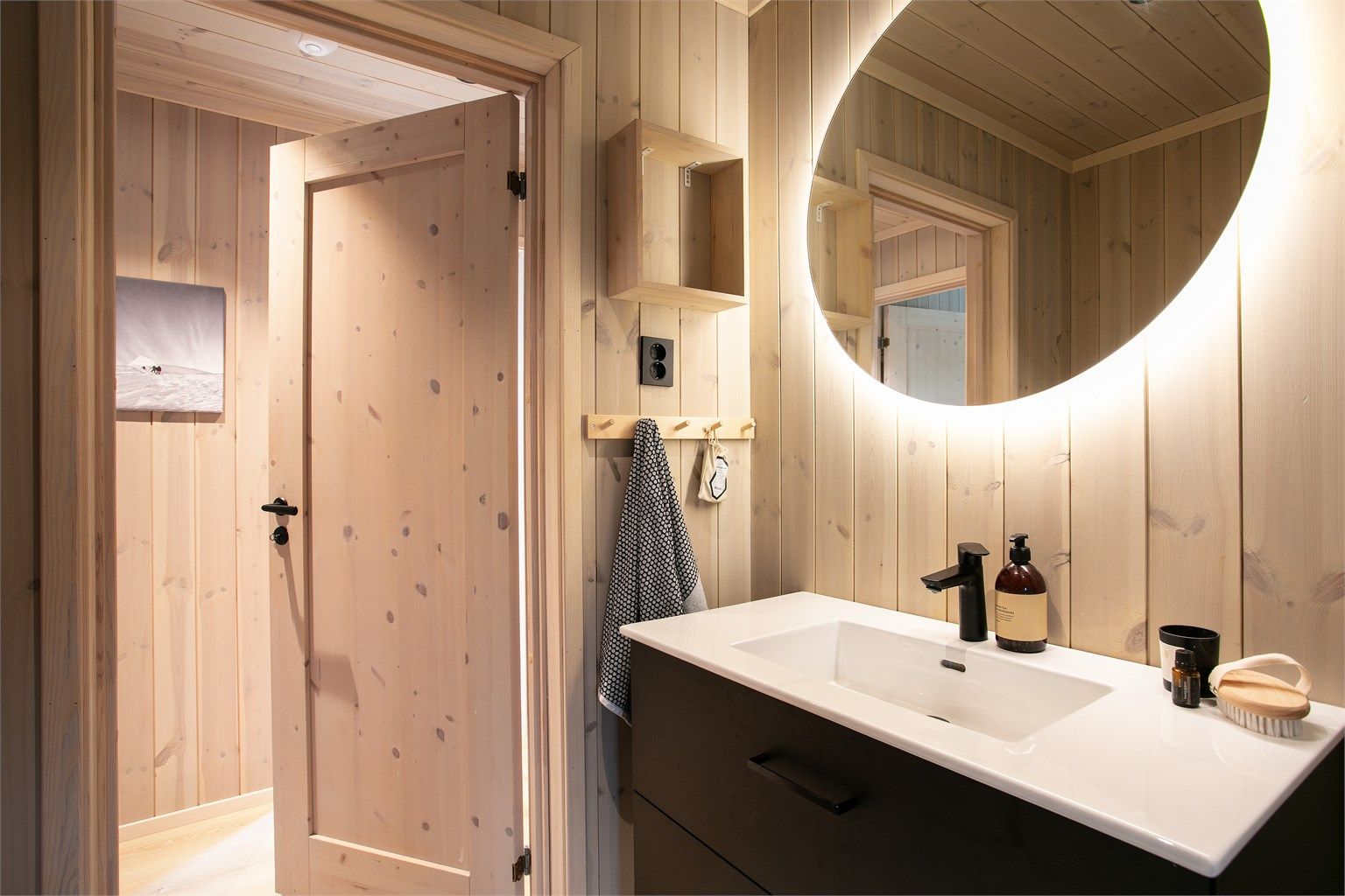 Badet har innredning med nedfelt servant og veggmontert toalett.
