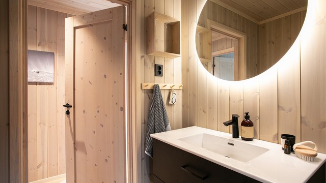 Badet har innredning med nedfelt servant og veggmontert toalett.