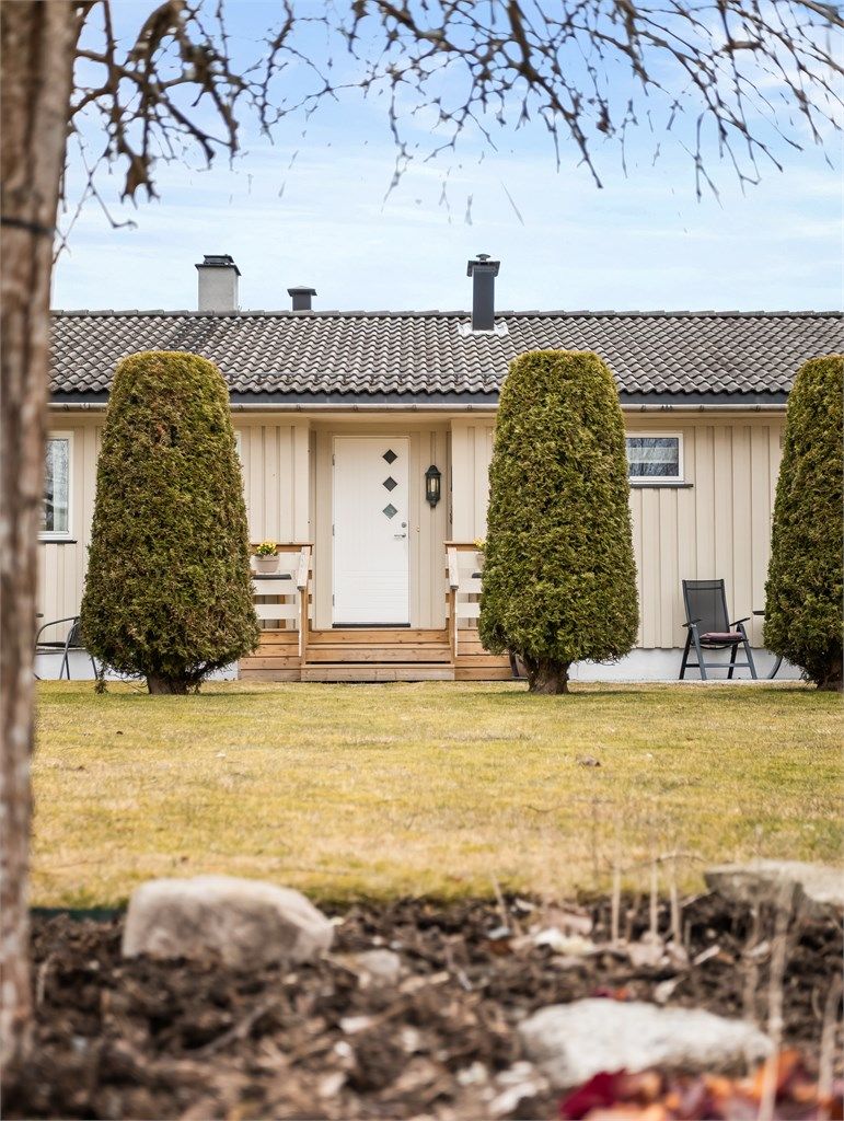 Eneboligen har en klassisk fasade med stående og liggende trepanel.