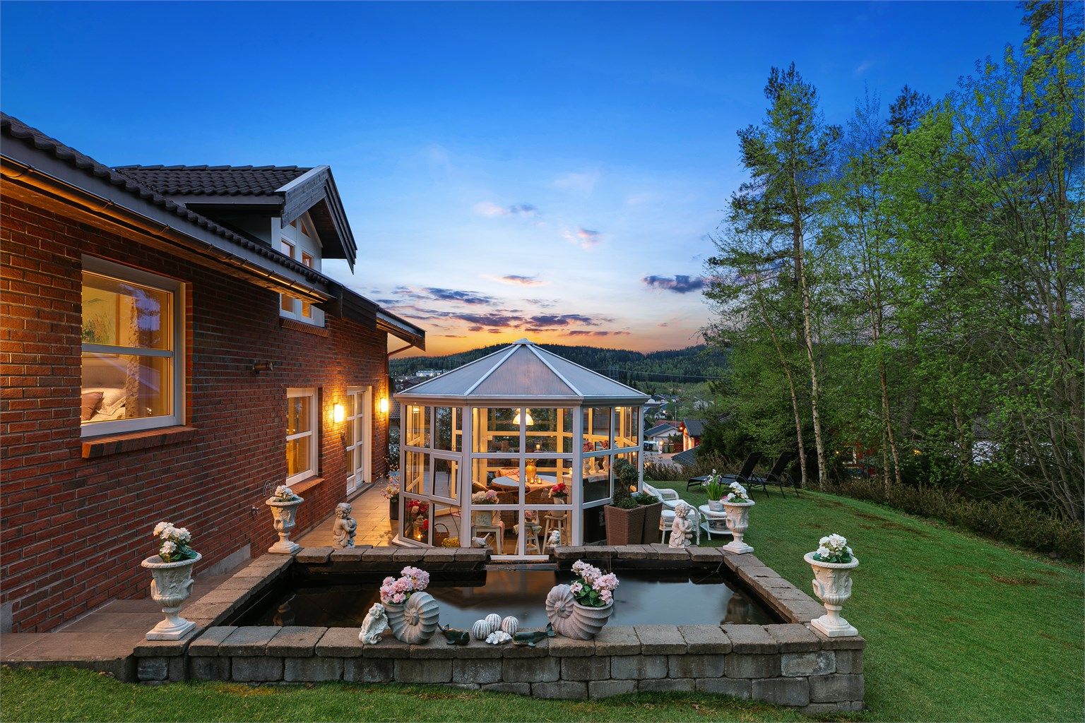 Bak hagestuen er det en idyllisk dam og fin dekorasjon.