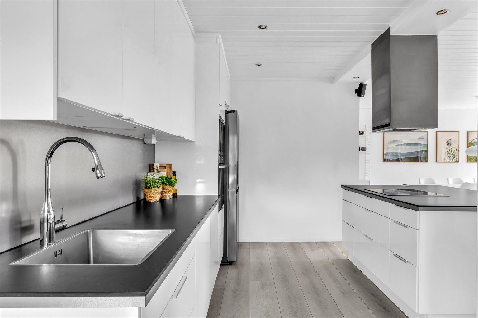 Med klassisk, glatt innredning, laminat benkeplate og takhøye overskap, har rommet et tidløst preg.