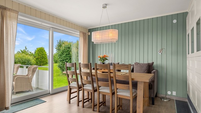 Den lyse spisestuen har god plass til et stort spisebord og ligger i en naturlig, sosial tilknytning til både kjøkkenet og stuen.