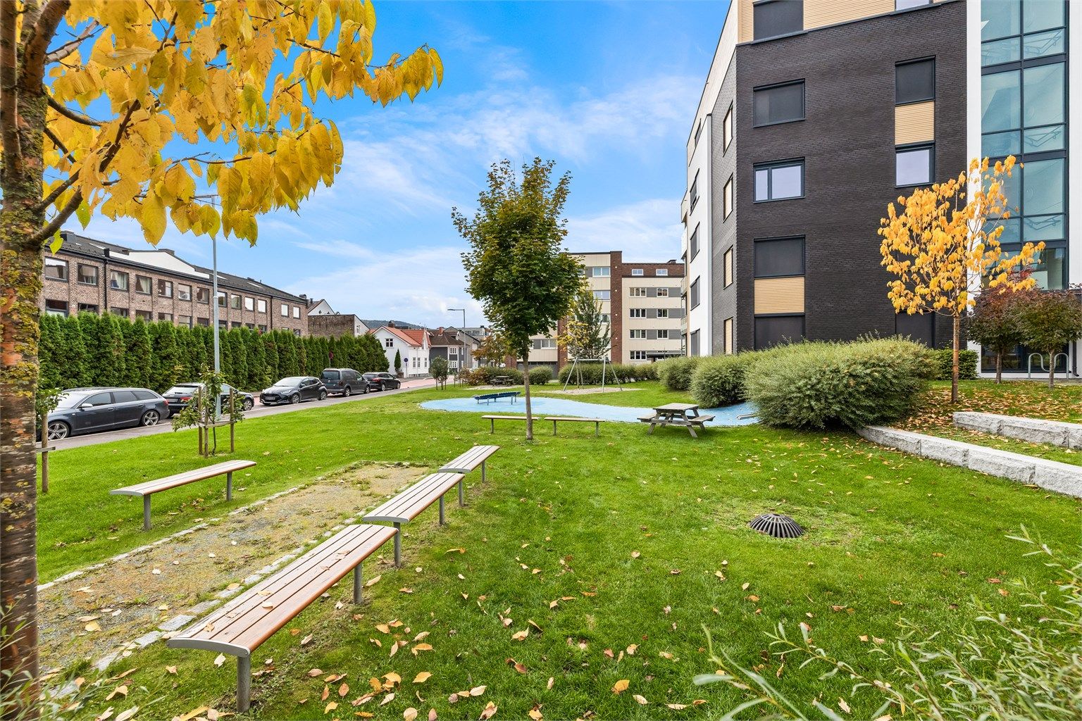 Felles atrium og parkområde med sitteplasser samt lekeapparater