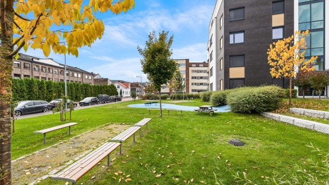 Felles atrium og parkområde med sitteplasser samt lekeapparater