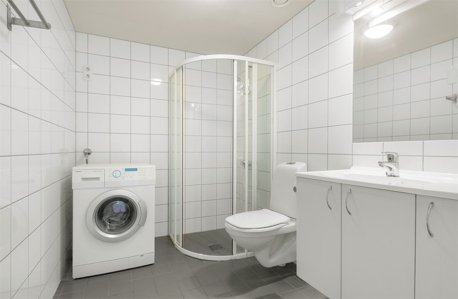 Romslig, flislagt bad fra byggeår med varmekabler i gulv og opplegg for vaskemaskin. 