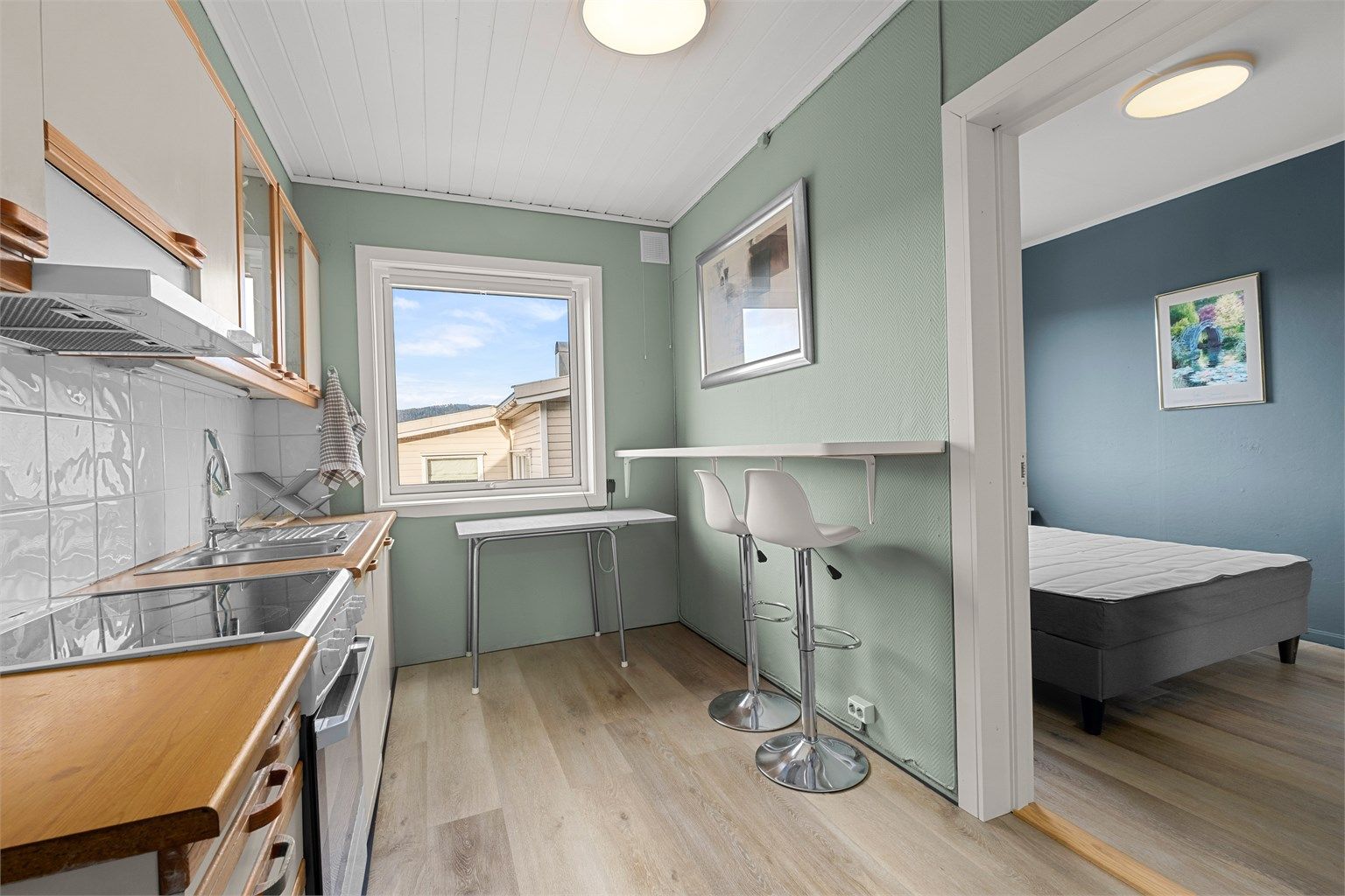 Kjøkkenet har en effektiv planløsning med plass til liten spiseplass, og vinduet slipper inn godt med dagslys.