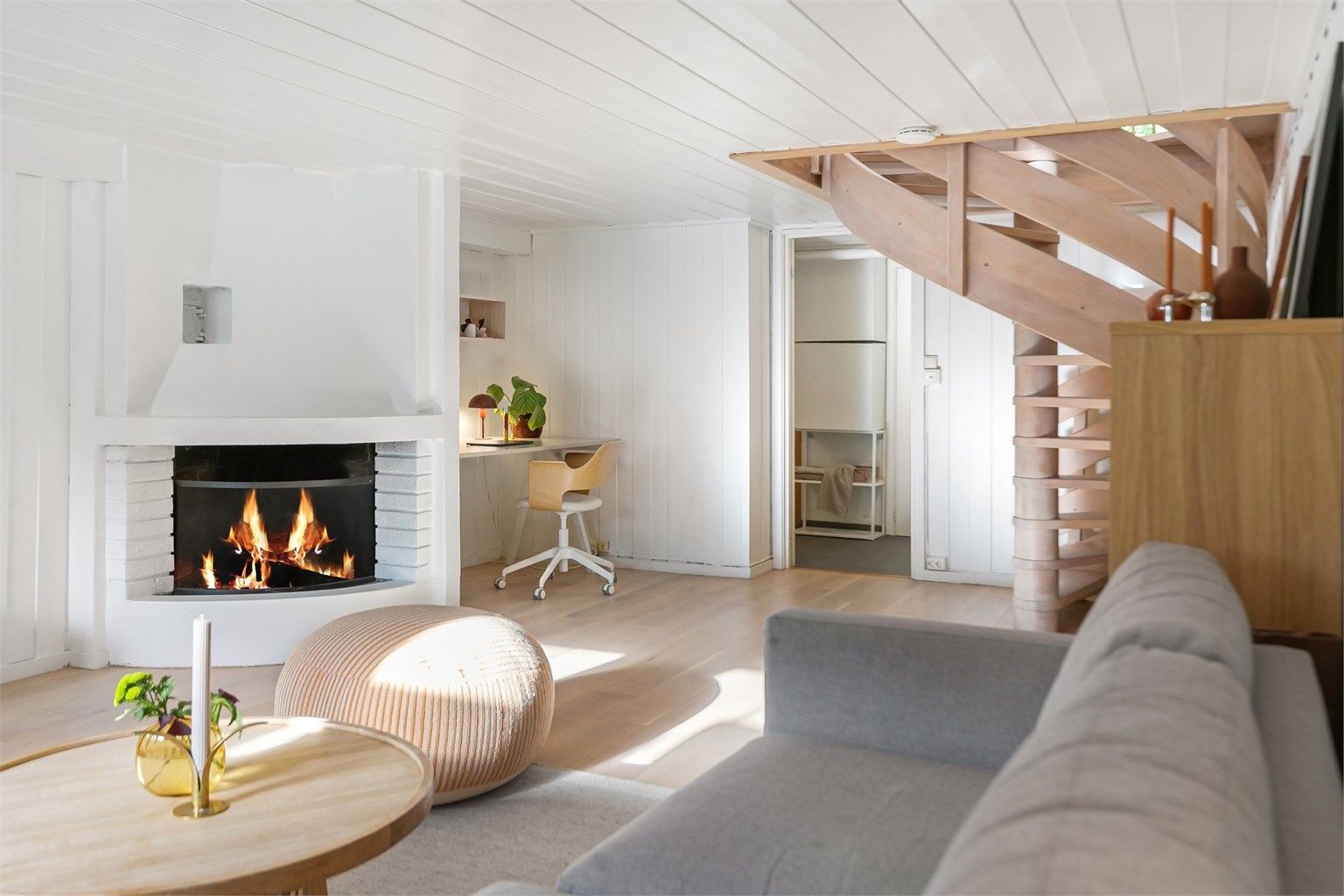 Kjellerstuen (ikke godkjent for varig opphold) har god plass til sofagruppe foran peisen og adkomst via spiraltrappen.