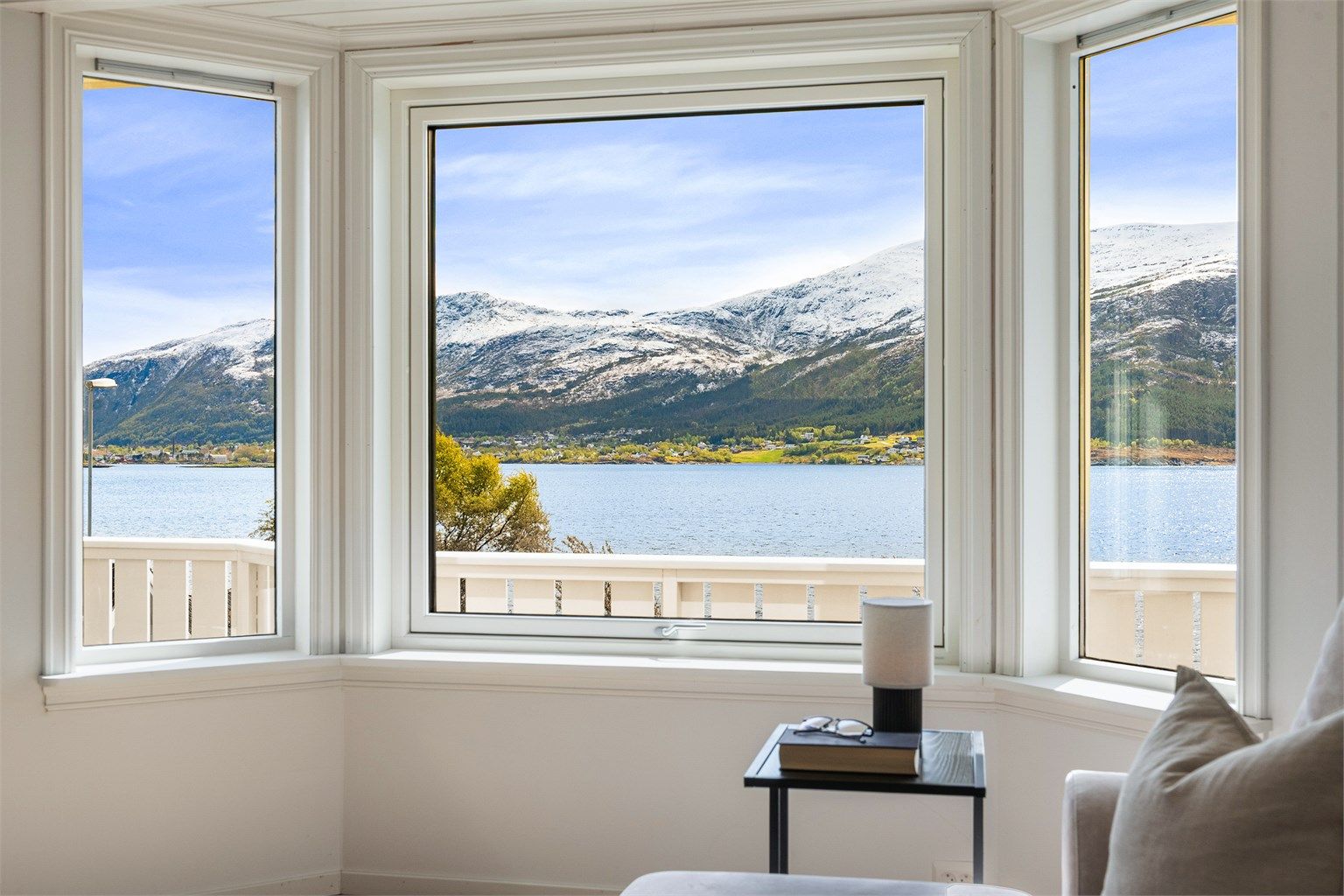 Store vindusflater i stuen rammer inn utsikten mot fjorden og fjellene