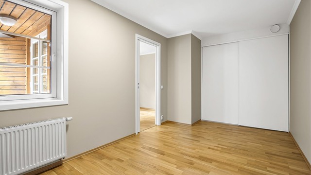 I enden av rommet er det en praktisk innebygd skyvedørsgarderobe i hvit og glatt utførelse.