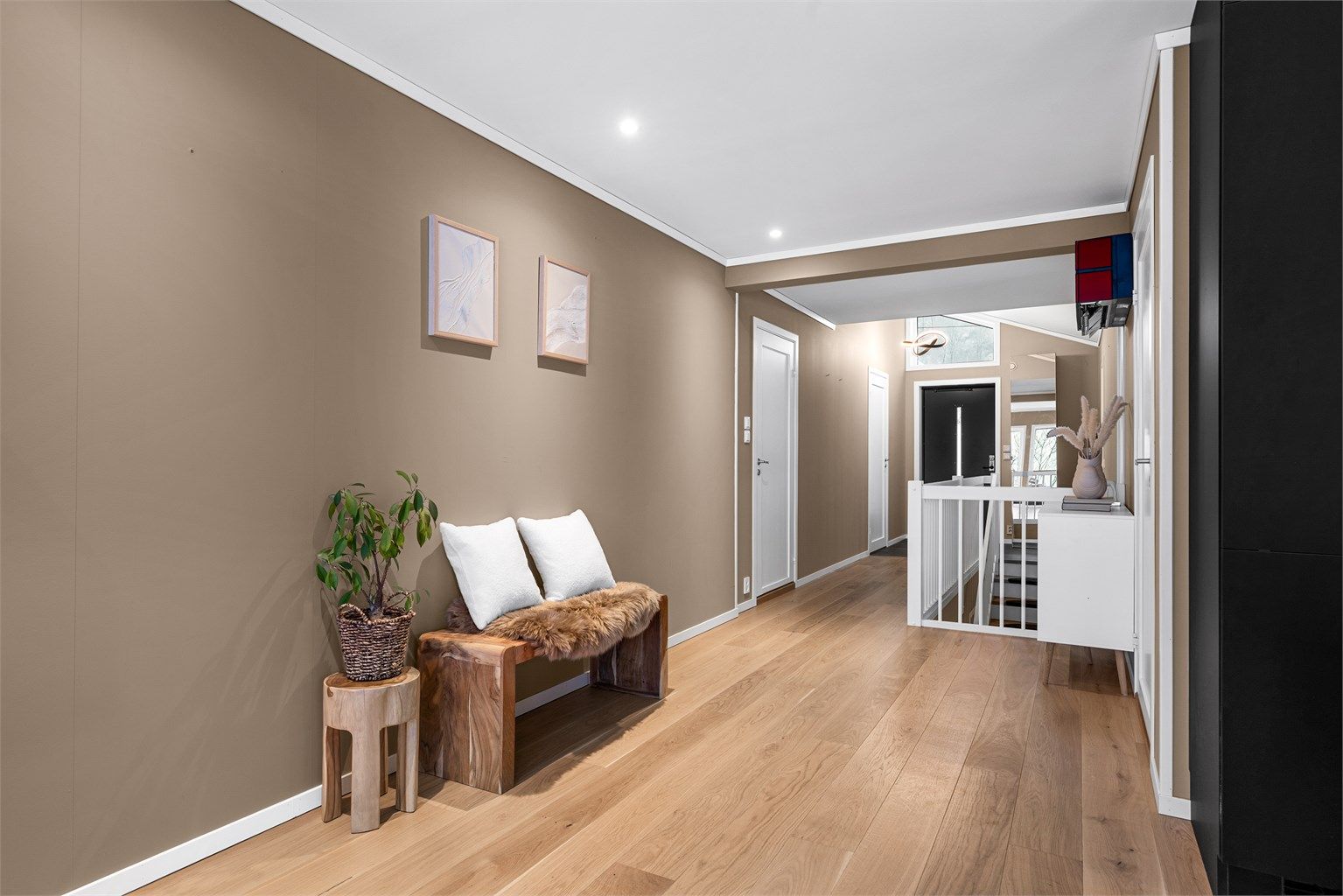 Fra stuen kommer man til en romslig gang med parkettgulv og downlights.