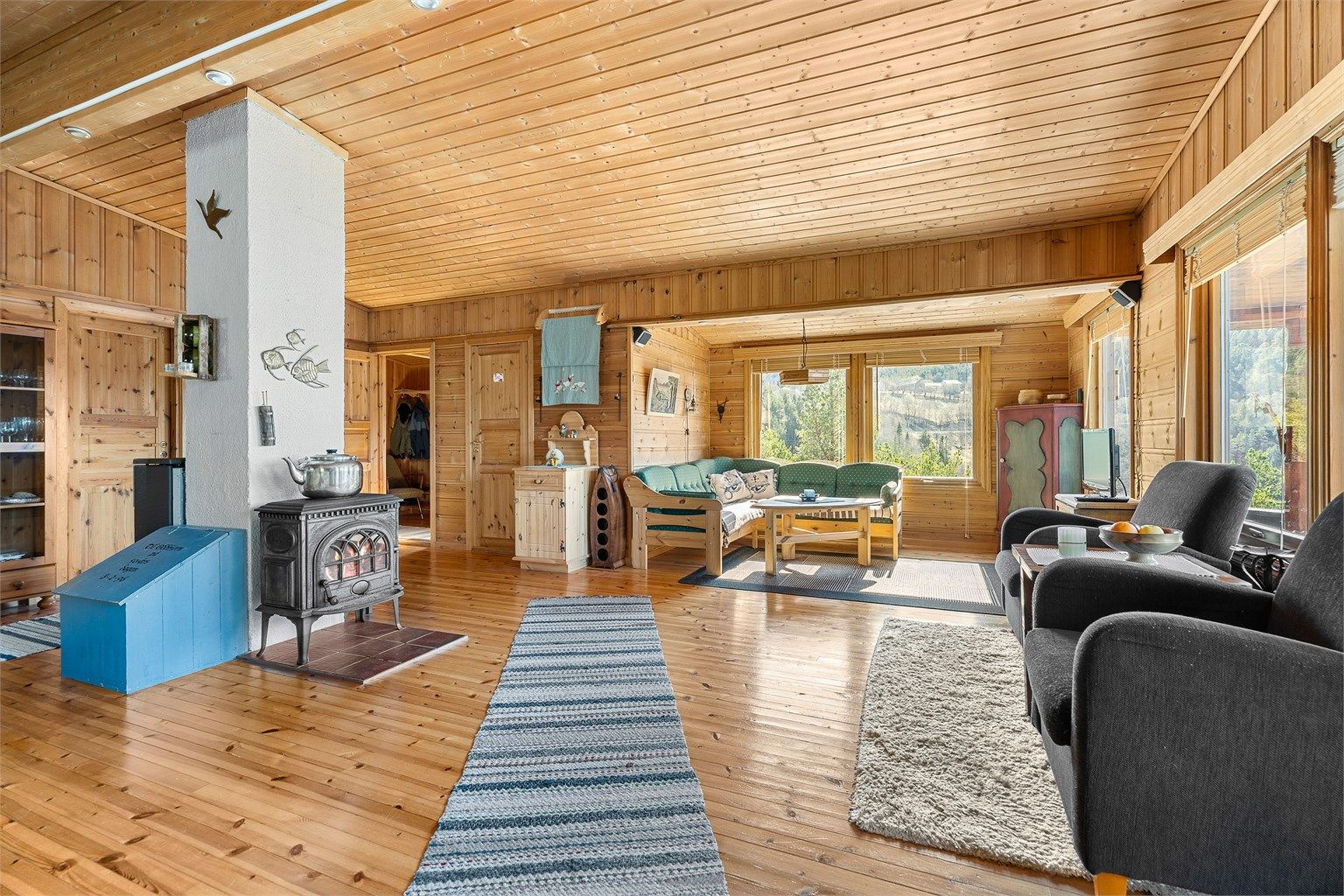 Romslig stue med vedovn som skaper en lun og varm atmosfære på kjølige dager.