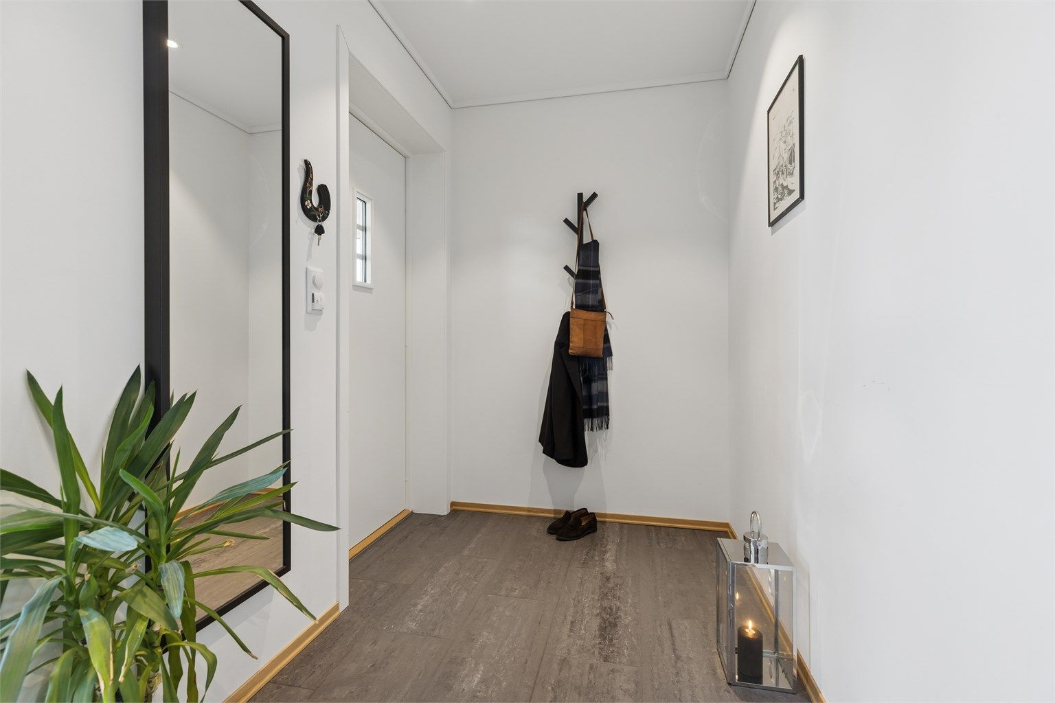 Velkommen inn! Gangen er romslig, med gulvvarme og et stort vinduet som slipper inn rikelig med naturlig lys og skaper et lyst og innbydende førsteinntrykk.